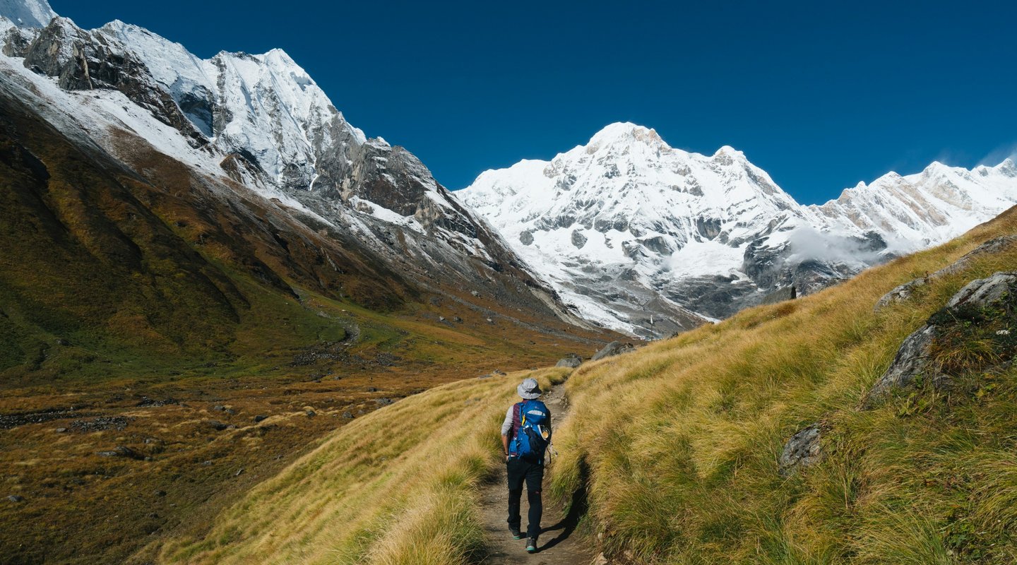 "Panoramic-view-of-Annapurna-Circuit-Trek-trail-with-snow-capped-Himalayas-and-trekkers in Nepal."