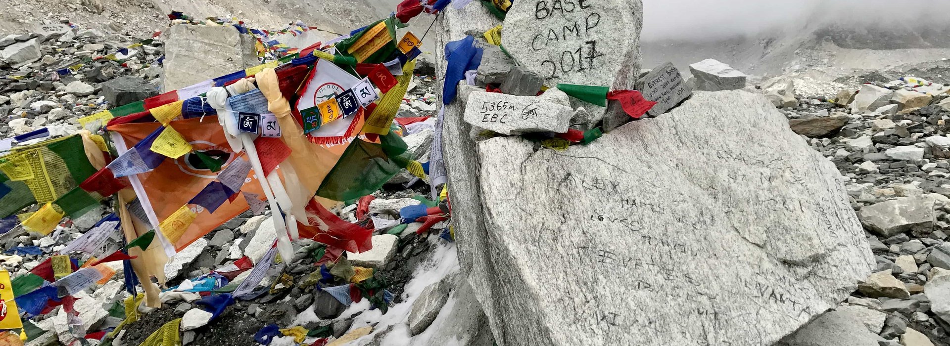 Everest Base Camp with colorful prayer flags and snowy peaks