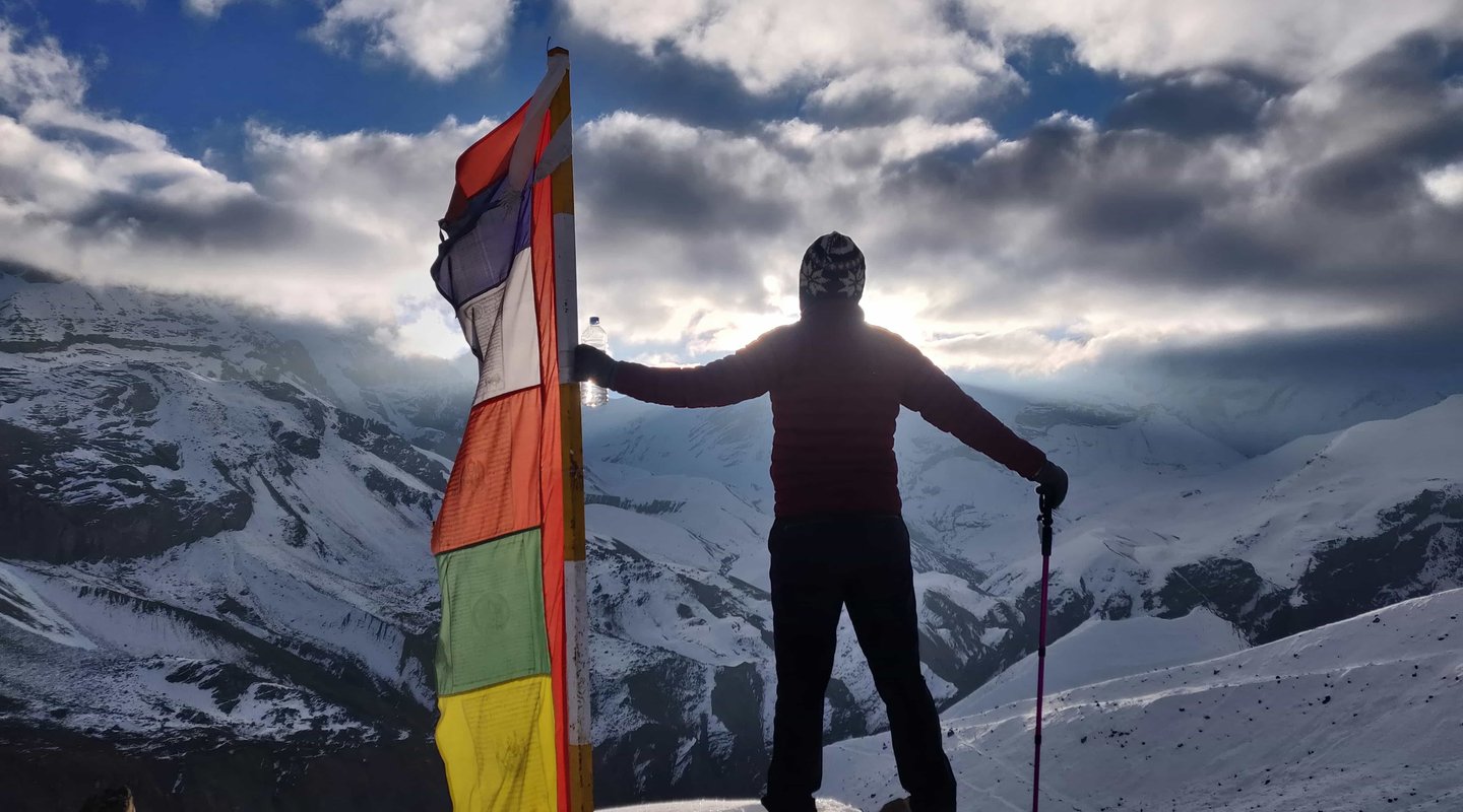 Traveler holding prayer flag at North Annapurna Base Camp viewpoint