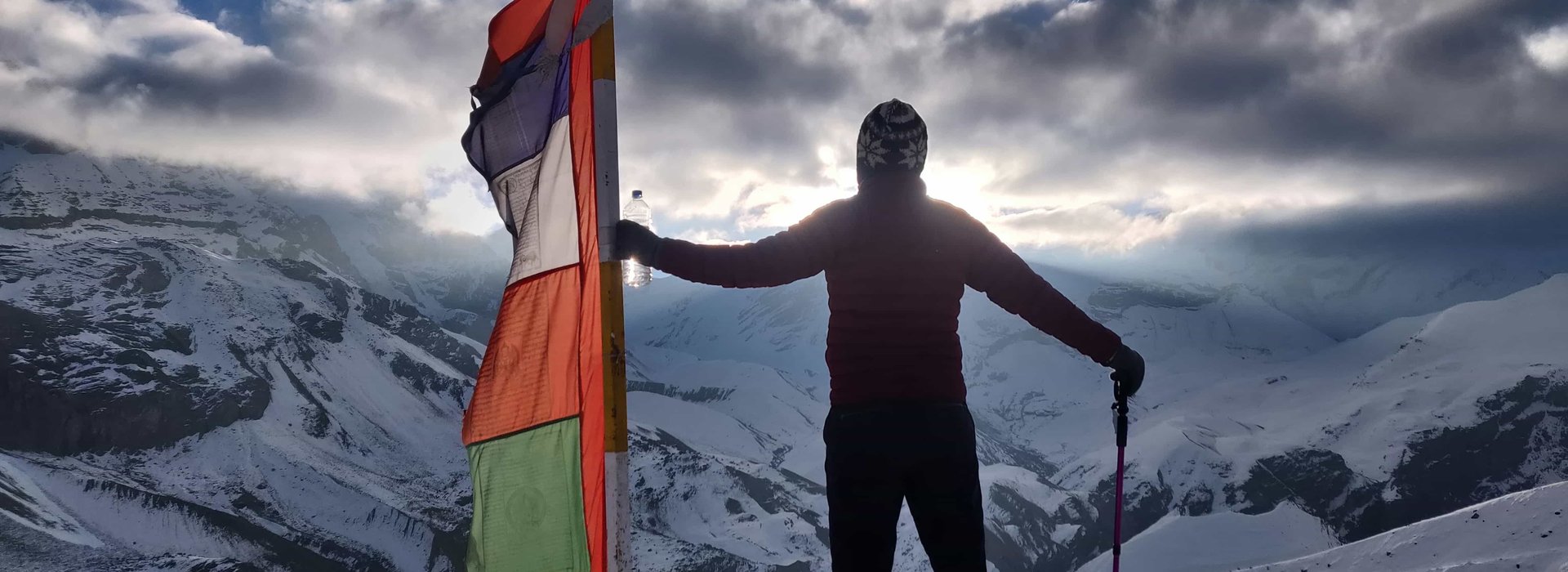 Traveler holding prayer flag at North Annapurna Base Camp viewpoint