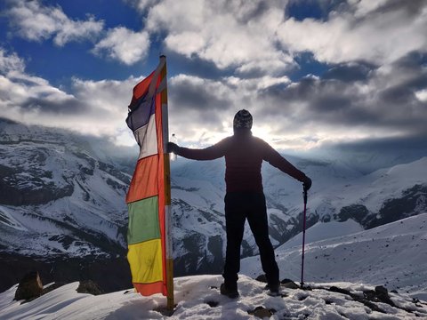 Traveler holding prayer flag at North Annapurna Base Camp viewpoint