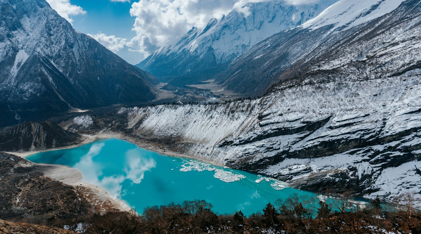 Glacial lake nestled among snow-covered peaks.