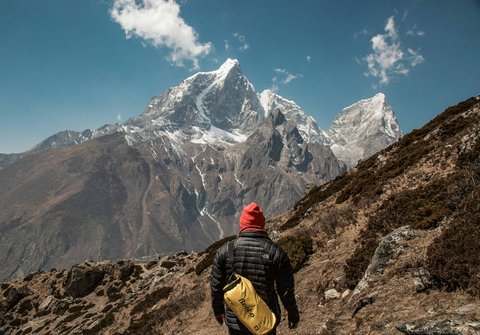 “Trekker walking on the Everest Three Pass trek trail with panoramic Himalayan mountain views in Nepal.”