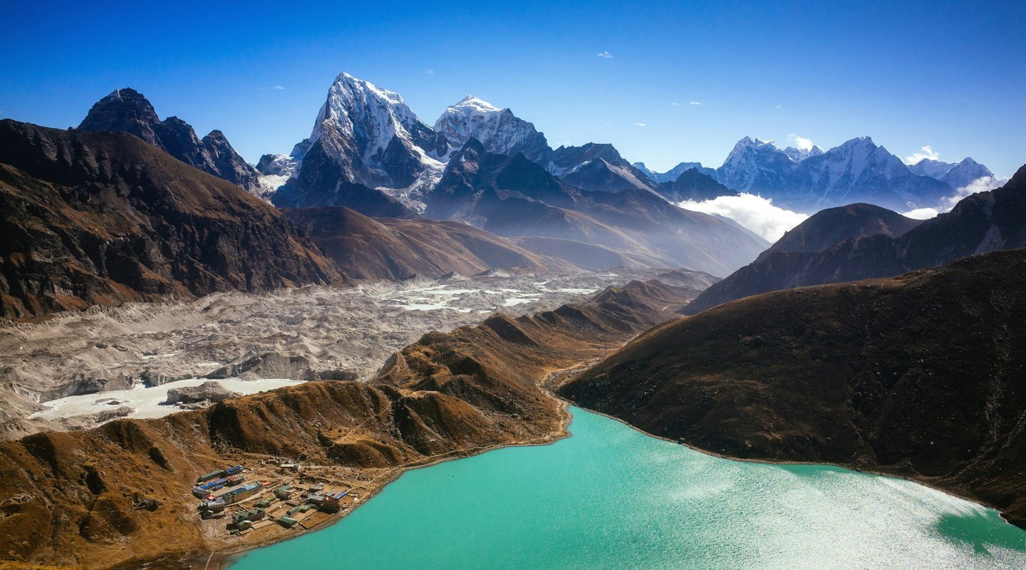 Turquoise Gokyo Lake with snow-capped Himalayan peaks and rugged valleys along the Gokyo Cho La Pass trek in Nepa