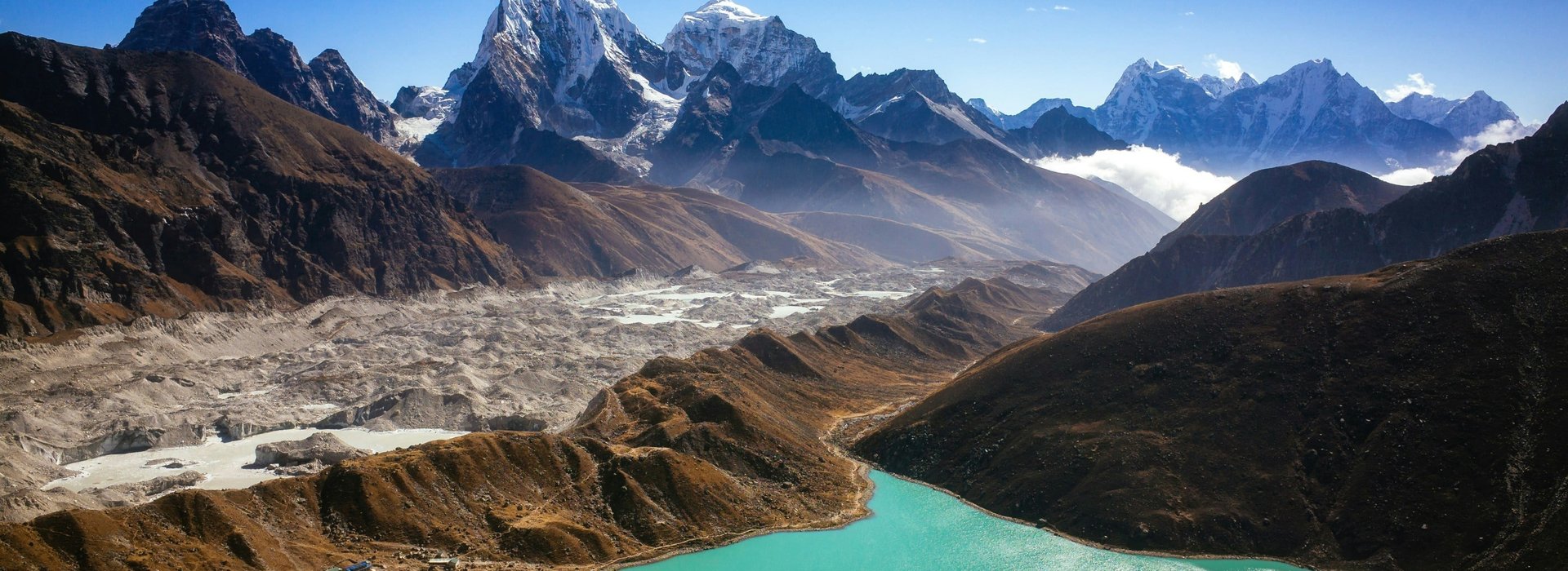 Turquoise Gokyo Lake with snow-capped Himalayan peaks and rugged valleys along the Gokyo Cho La Pass trek in Nepa