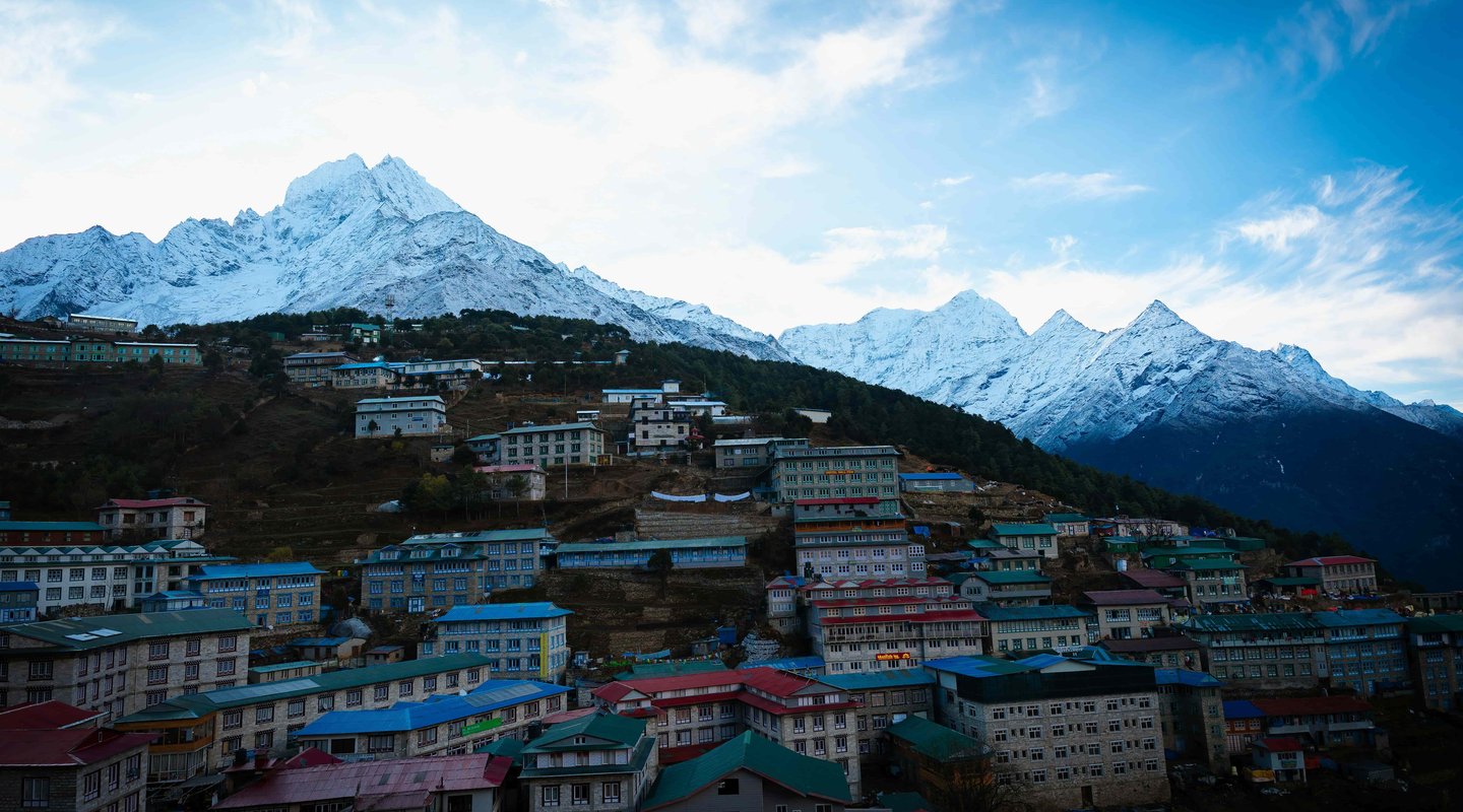Namche Bazaar with colorful houses and lodges beneath snow-capped Himalayan peaks on the Jiri to Everest Base Camp trek route in Nepal