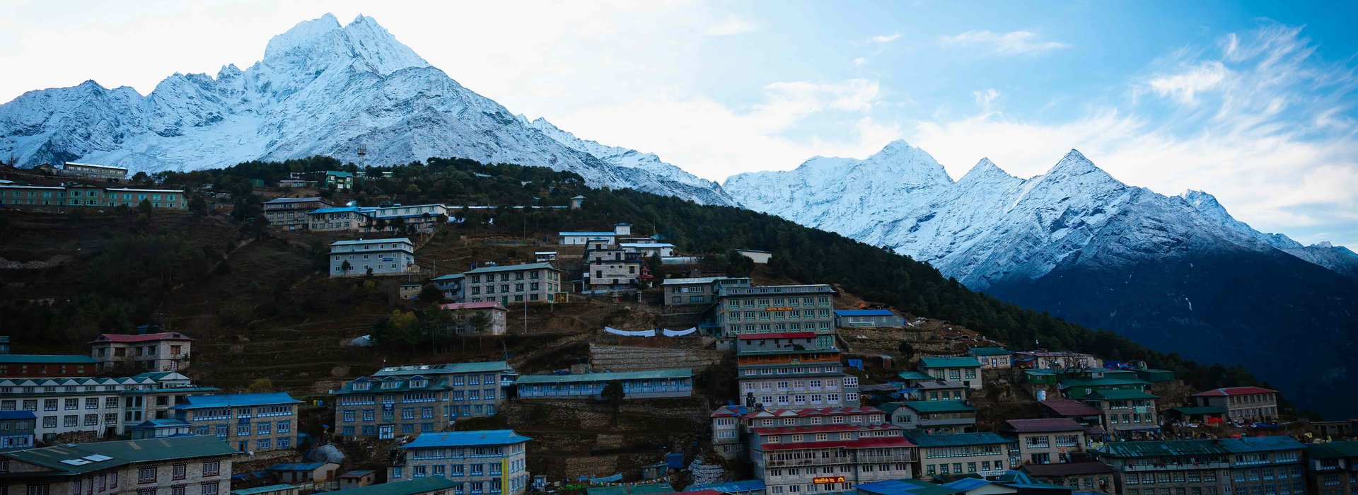 Namche Bazaar with colorful houses and lodges beneath snow-capped Himalayan peaks on the Jiri to Everest Base Camp trek route in Nepal