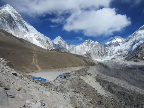 “View of Everest Base Camp with surrounding snow-capped Himalayan peaks, rocky trails, and teahouse settlements along the Khumbu Valley during the Everest Base Camp trek by road.”