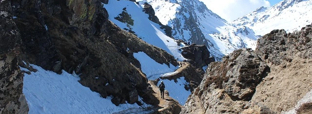 Trekking trail in the Langtang Helambu region with snow-covered mountains and a narrow high-altitude path