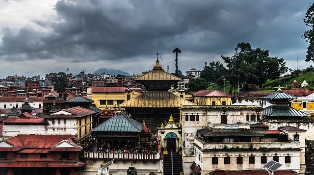 View of Pashupatinath Temple complex in Kathmandu, Nepal under dramatic monsoon clouds — famous Hindu pilgrimage site and UNESCO World Heritage landmark.