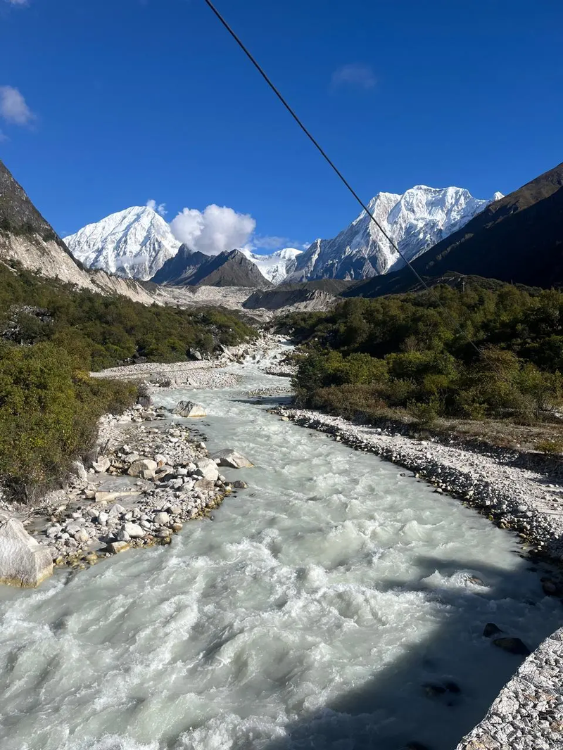 River flowing through the Manaslu Valley along the Short Manaslu Circuit Trek route, surrounded by steep mountain slopes.