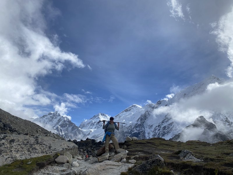 Confident solo female trekker posing at Everest Base Camp sign 5364m altitude achievement with Mount Everest view