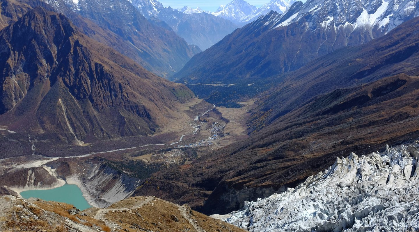 Steep mountain path along the Budhi Gandaki River valley on the Manaslu Circuit, flanked by terraced fields.
