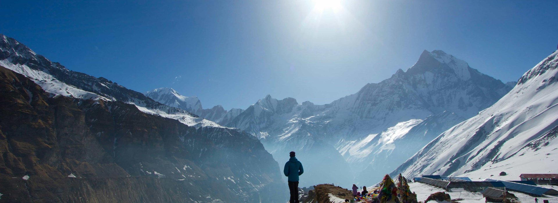 Solo trekker on mountain trail with Machapuchare (Fishtail) peak visible in distance