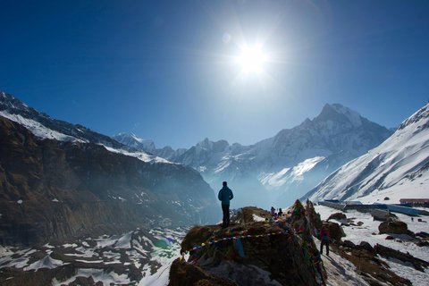 Solo trekker on mountain trail with Machapuchare (Fishtail) peak visible in distance