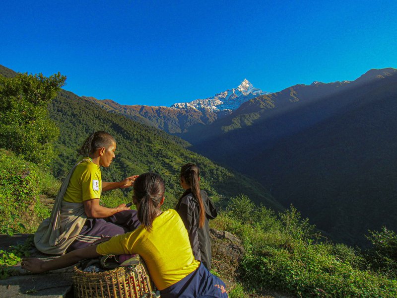 Trekker resting with panoramic view of Mount Annapurna at North Base Camp
