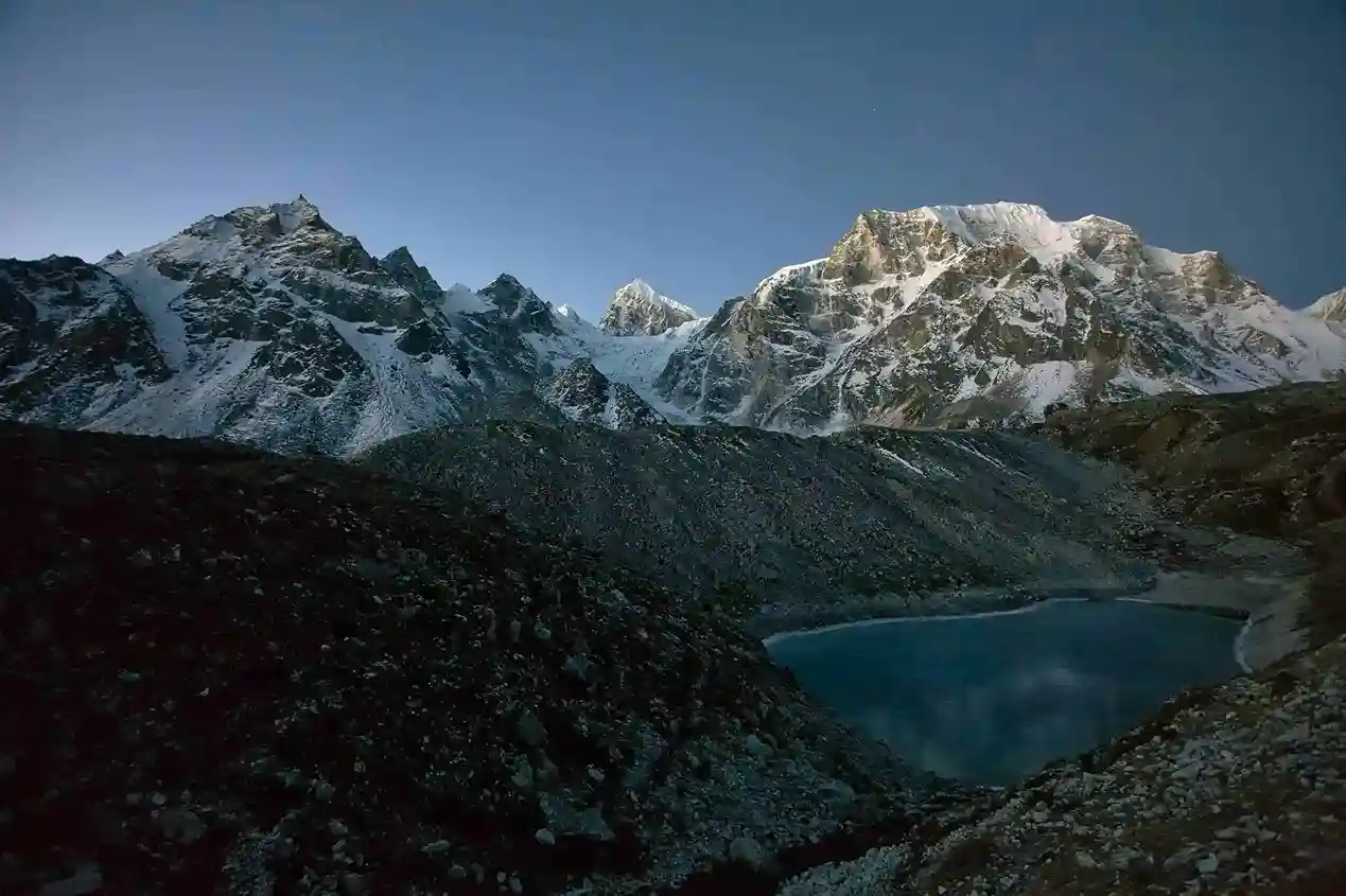Manaslu Circuit Trek view with a pristine alpine lake in the foreground and towering Himalayan peaks in the background, Nepal.
